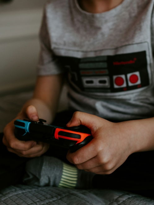 kid sitting on gray bed while playing